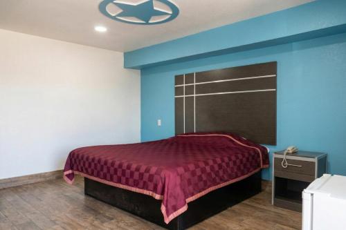 a bedroom with a bed with a red bedspread at Golden Motel Near Houston Medical Center in Houston