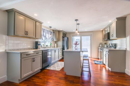 a large kitchen with wooden floors and stainless steel appliances at Cape Cod Home—Deck, Near Canal Bike Path in Sandwich
