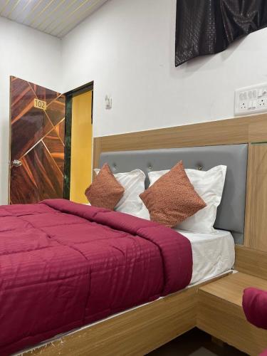a bedroom with a bed with red sheets and pillows at Jazz residency hotel in Mumbai