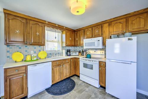 a kitchen with white appliances and wooden cabinets at Sagamore Beachfront Cottage Escape in Sagamore Beach