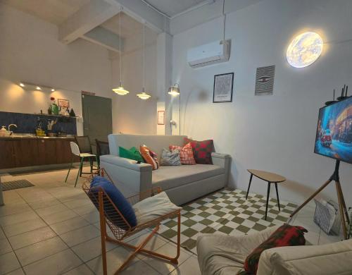 a living room with a couch and a tv at Dramatic Exit Bangkok - Cozy Loft House near Suvarnabhumi Airport in Bangkok