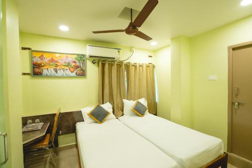 a bedroom with a bed and a ceiling fan at Icon vista hotel in Tirupati