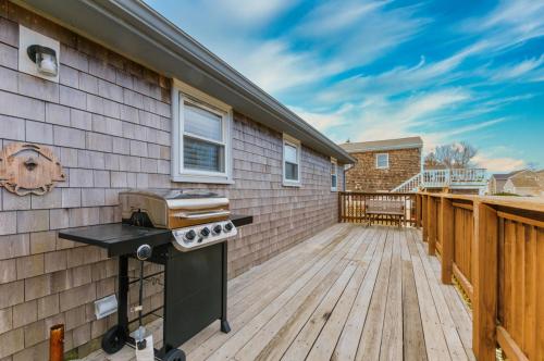 a backyard with a grill on a wooden deck at Family Cape Escape—Beach, Boardwalk Game Room in Sandwich