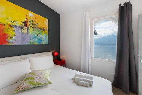 a bed with a teddy bear on it in a bedroom with a window at Residence La Mignon Terrazza in Torri del Benaco
