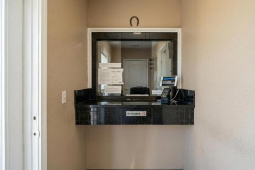 a reflection of a reception desk in a mirror at Golden Motel Near Houston Medical Center in Houston