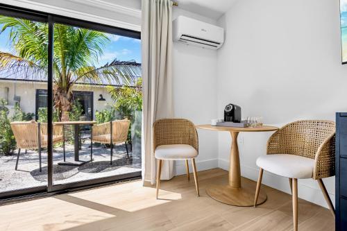 a room with a table and chairs and a large window at The Retreat at Anna Maria Island Inn in Bradenton Beach