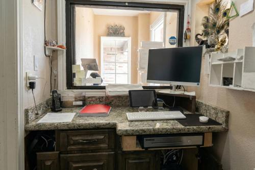 a computer desk with a monitor and a keyboard at Golden Motel Near Houston Medical Center in Houston