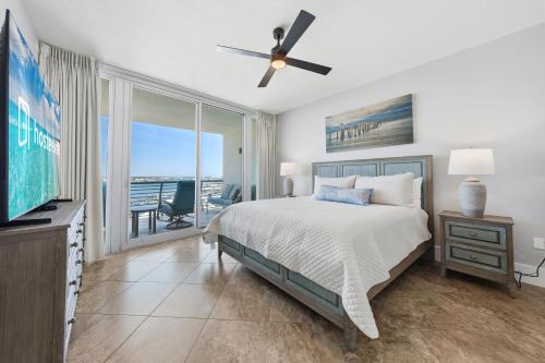 a bedroom with a bed and a tv and a balcony at Bella Luna 908 in Orange Beach