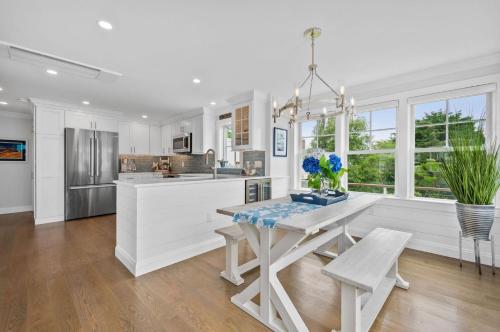 a white kitchen with a table and a dining room at Happy As A Clam in Chatham