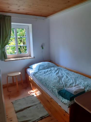 a bedroom with a bed in a room with a window at Ferienhaus Petersen in Langeneß