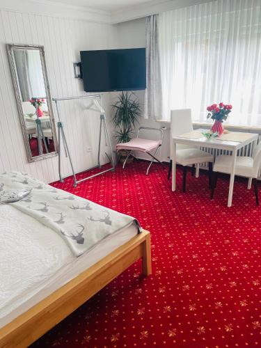 a bedroom with a bed and a table and chairs at Haus Anna-Marie in Feldberg