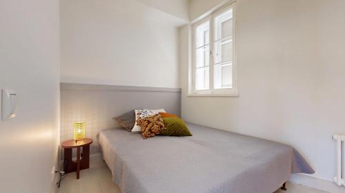 a small bedroom with a bed with a window at tARTu Stays 5-3 Spacious Apartment Tartu Old Town in Tartu
