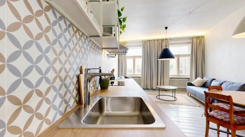 a kitchen with a sink and a living room at tARTu Stays 5-3 Spacious Apartment Tartu Old Town in Tartu