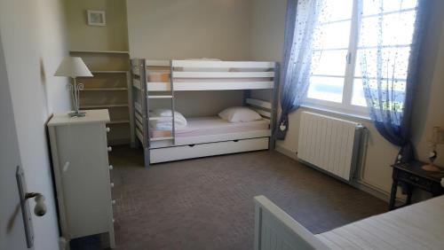 a small bedroom with bunk beds with a window at Le Couvent in Lagardelle