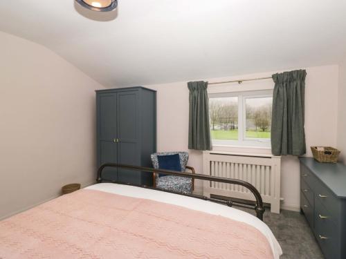 a bedroom with a bed and a chair and a window at Dakota in Holmrook