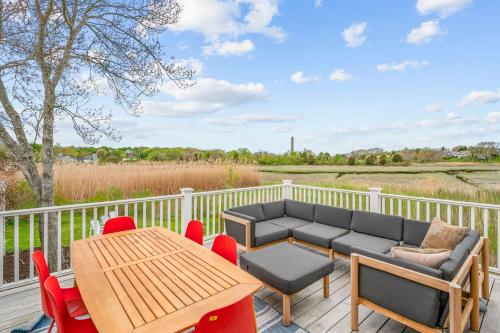 a patio with a couch and a table and chairs at Marshside Cape Escape with Space Views in Sandwich