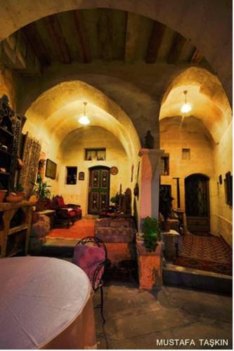 a living room with an archway and a room with a table at Sofa Hotel in Avanos