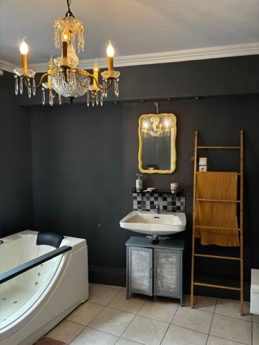 a bathroom with a tub and a sink and a chandelier at Gemütlicher Oase mit eigenen Bad in Zentrale, jedoch ruhige Lage in Mönchengladbach