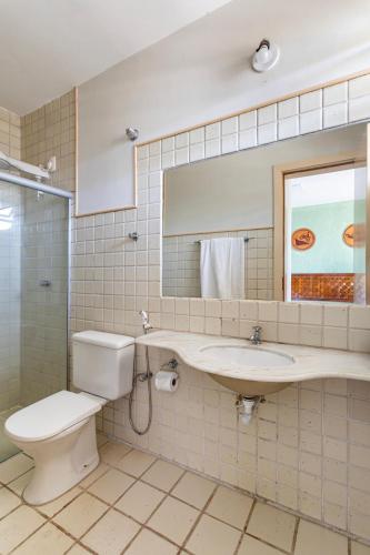 a bathroom with a toilet and a sink and a mirror at Rio Quente Resorts - Eco Chalés in Rio Quente