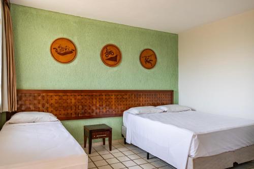 a room with two beds and three plates on the wall at Rio Quente Resorts - Eco Chalés in Rio Quente