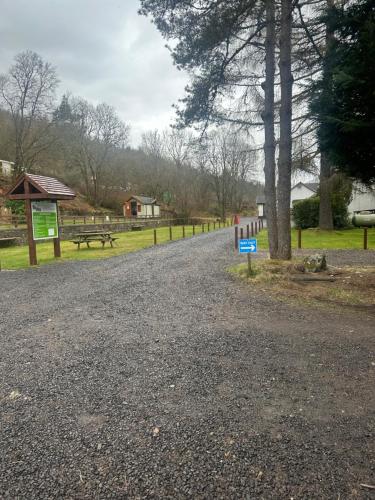 a gravel road in a park with a picnic table at By The Way Campsite, Trekker, Nevis in Tyndrum