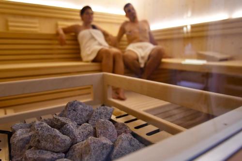 two men sitting in a sauna with a tray of cookies at Pension Sonnenhof in Maranza
