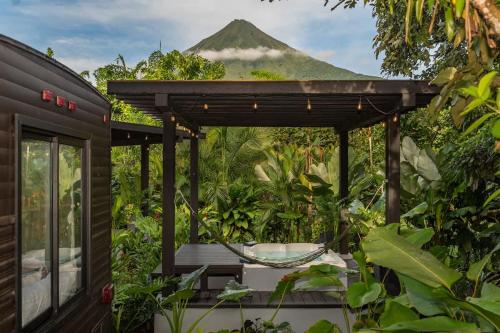 a house with a hammock and a mountain in the background at Rolling Green Oasis in Fortuna