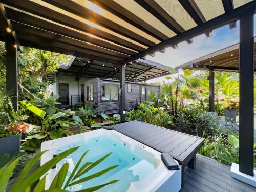 an outdoor hot tub in a garden with a pergola at Rolling Green Oasis in Fortuna