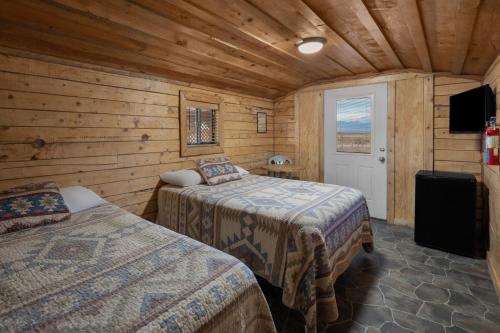 a bedroom with two beds in a wooden room at Sun Outdoors Canyonlands Gateway in Moab