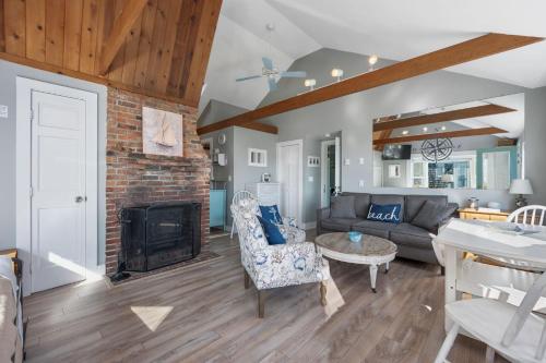 a living room with a couch and a fireplace at Lost at Seaside – Your Cozy Coastal Hideaway in South Yarmouth