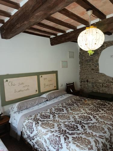 a bedroom with a bed and a chandelier at B&B Paradiso in Gubbio