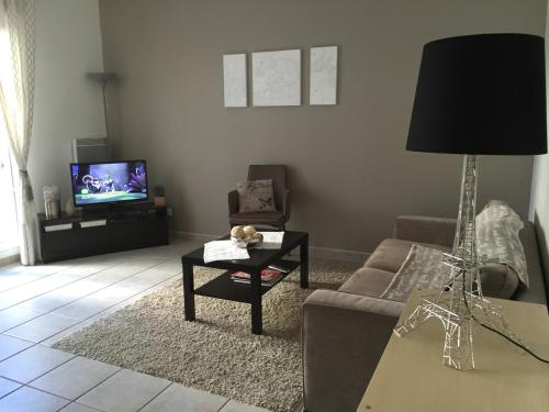 un salon avec un canapé et une télévision dans l'établissement Jardin&Terrasse Disneyland Paris, à Serris