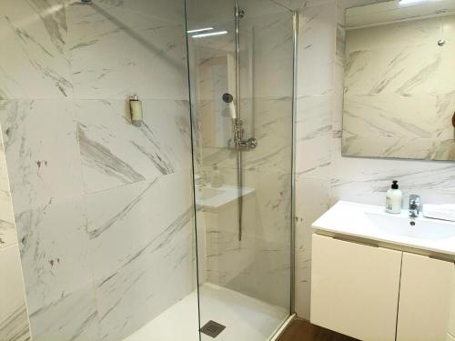 a white bathroom with a shower and a sink at Iberflat Apartamentos Marynton in Benicarló