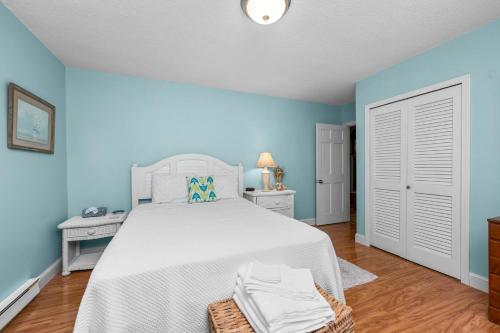 a bedroom with a white bed and blue walls at Cape Cod Escape – 1 Mile to Beach, A/C Grill in Centerville