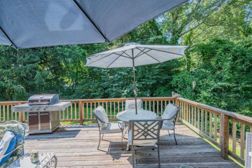 a table and chairs on a wooden deck with an umbrella at Cape Cod Escape – 1 Mile to Beach, A/C Grill in Centerville