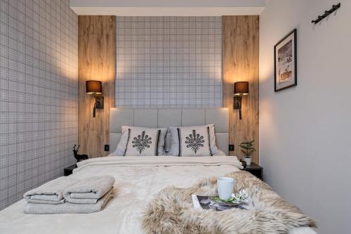 a bedroom with a large bed with blankets and pillows at BANIA BLACK MOUNTAIN I basen & spa in Białka Tatrzańska