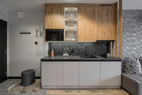 a kitchen with white cabinets and a sink at BANIA BLACK MOUNTAIN I basen & spa in Białka Tatrzańska