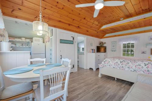 a bedroom with a table and a bed and a kitchen at Seaglass Cottage – Where Calm Meets Tide in South Yarmouth
