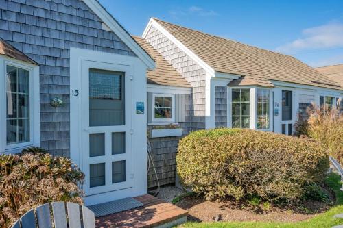 a house with a white door and windows at Seaglass Cottage – Where Calm Meets Tide in South Yarmouth