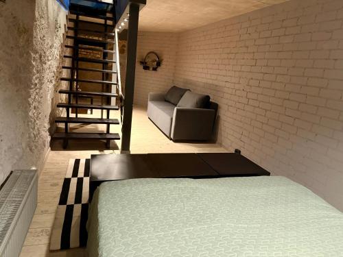 a bedroom with a bed and a couch in a room at Traku14 Old Town Yoga Studio in Vilnius