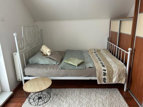 a white bed with a teddy bear sitting on it at Dom pri Veži in Košice