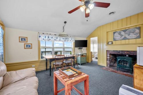a living room with a table and a fireplace at Peaceful Covefront Cottage Retreat in Eastham in Eastham