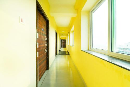 an empty hallway with yellow walls and windows at Hotel O Grand 55 in Bālianta