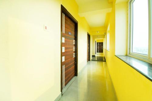 a hallway with a wooden door and a window at Hotel O Grand 55 in Bālianta