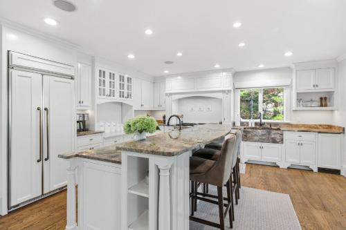 a kitchen with white cabinets and a large island at Peaceful Cape Cod Escape with Pond Views Hot Tub in Sandwich