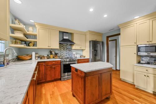 a kitchen with wooden cabinets and a stove top oven at Spacious Dog-Friendly Retreat in Chatham in Chatham