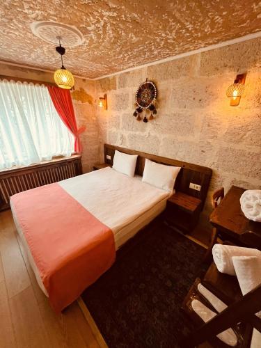 a bedroom with a bed and a table in a room at Cherrykonak cappadocia in Uçhisar
