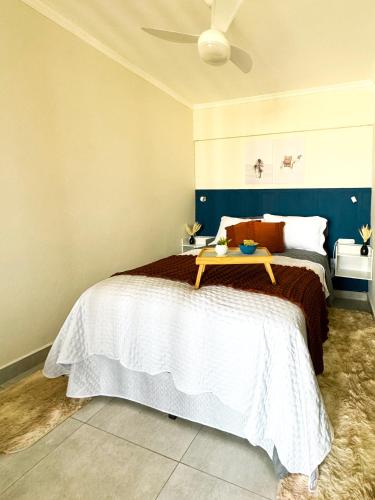 a bedroom with a bed with a table on it at Studio 43 - Central Coração de Franca in Franca
