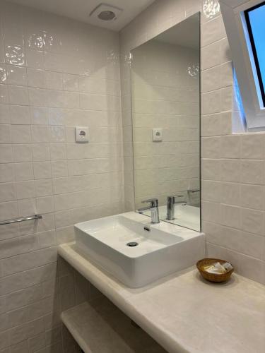 a white bathroom with a sink and a mirror at CASA da PISCINA, Quinta do Espinho, Douro Valley in Tabuaço