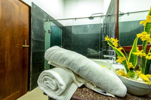 a bathroom with a towel on a counter next to a sink at Owinmo Hotel & reception Hall in Galle